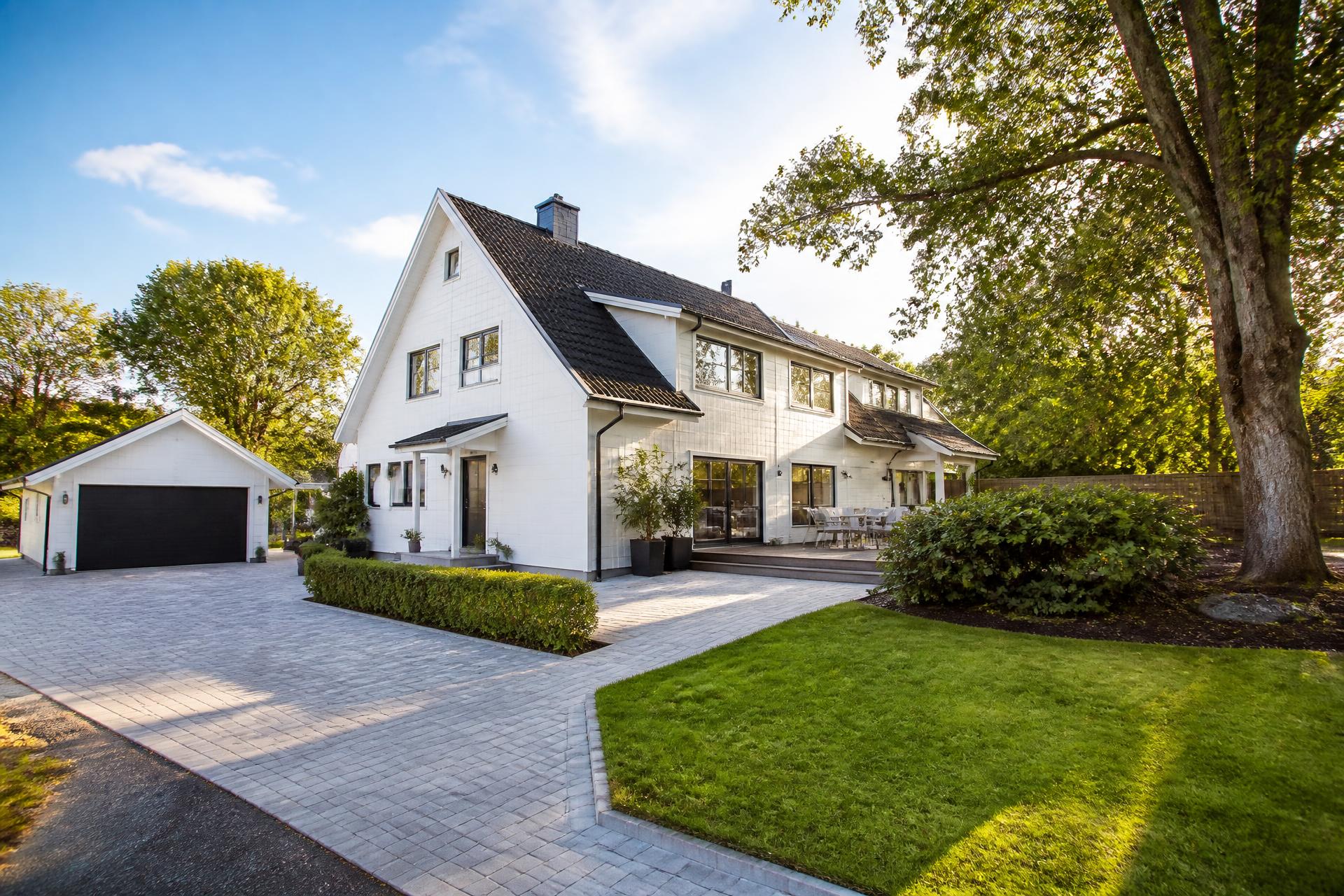 Nyrengjord vit villa med skinande ren stenlagd uppfart i Torslanda